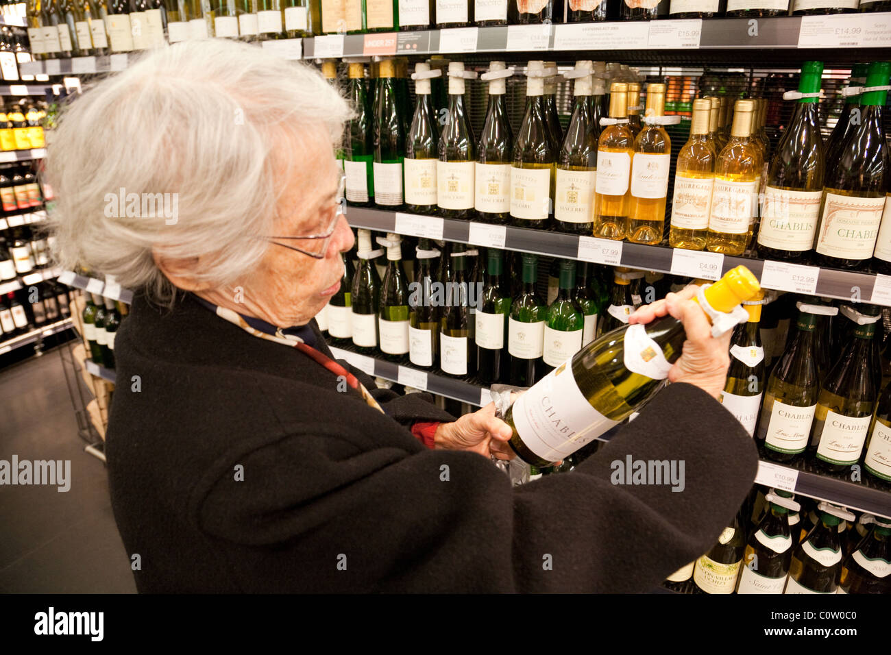 An elderly senior  woman buying wine alcohol , Marks and Spencer, Bromley UK Stock Photo