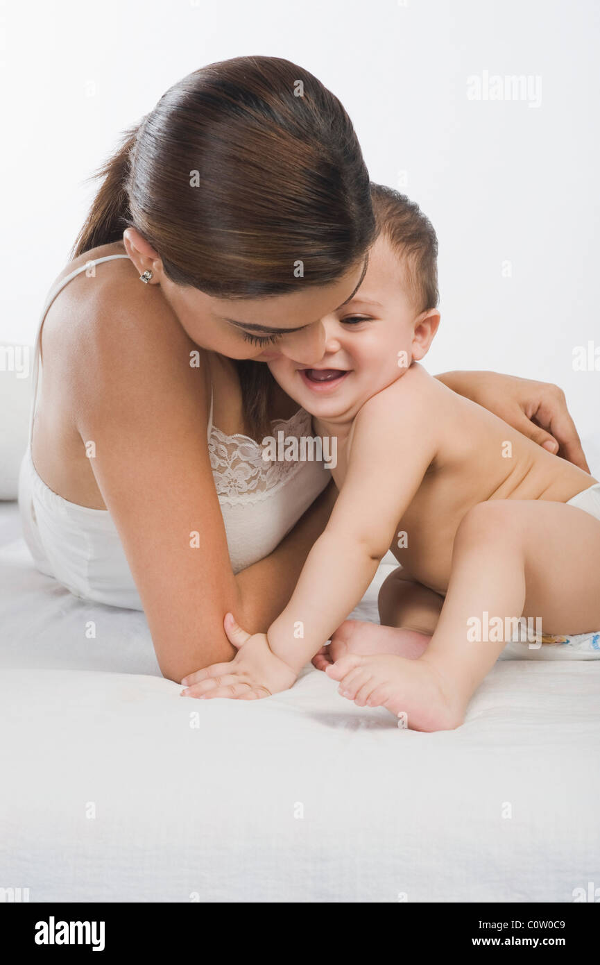 Woman playing with her son on the bed Stock Photo