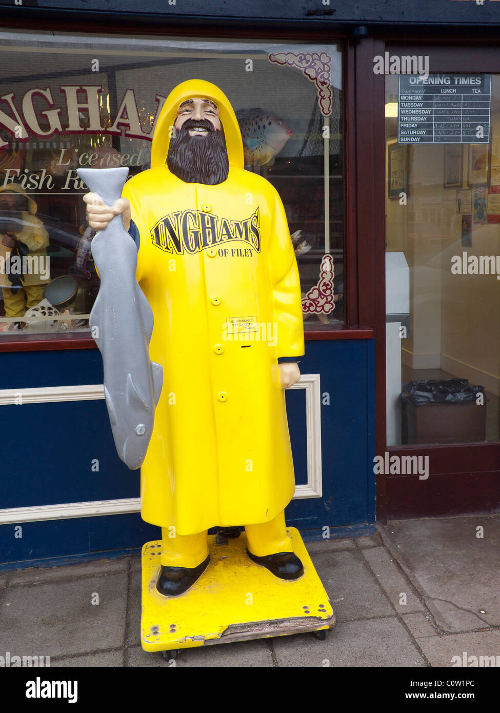A yellow manikin in the form of a fisherman in yellow oilskins at Inghams fish and chip shop Filey, North Yorkshire UK Stock Photo