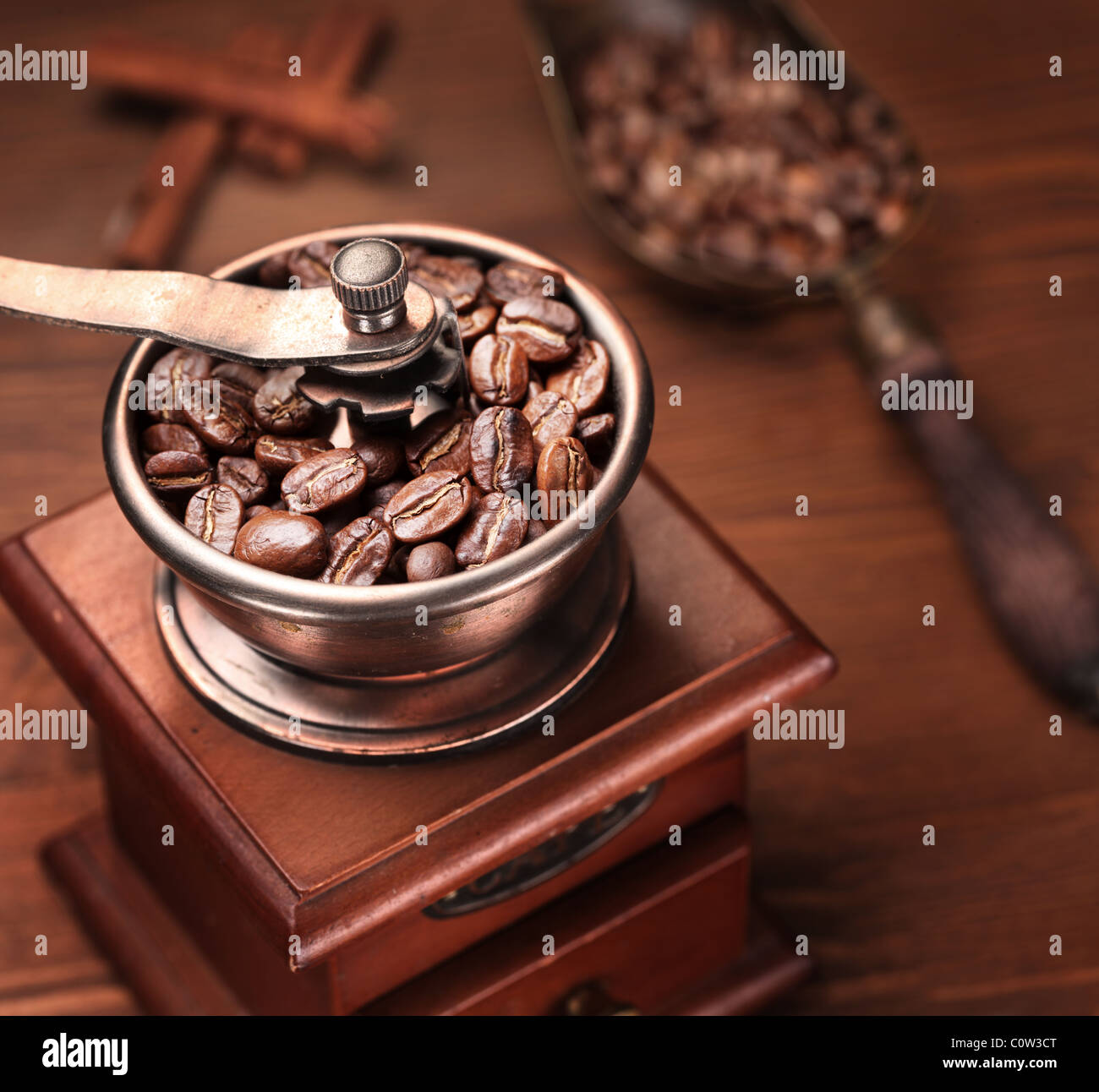 Roasted coffee beans are ground in a coffee grinder. Stock Photo