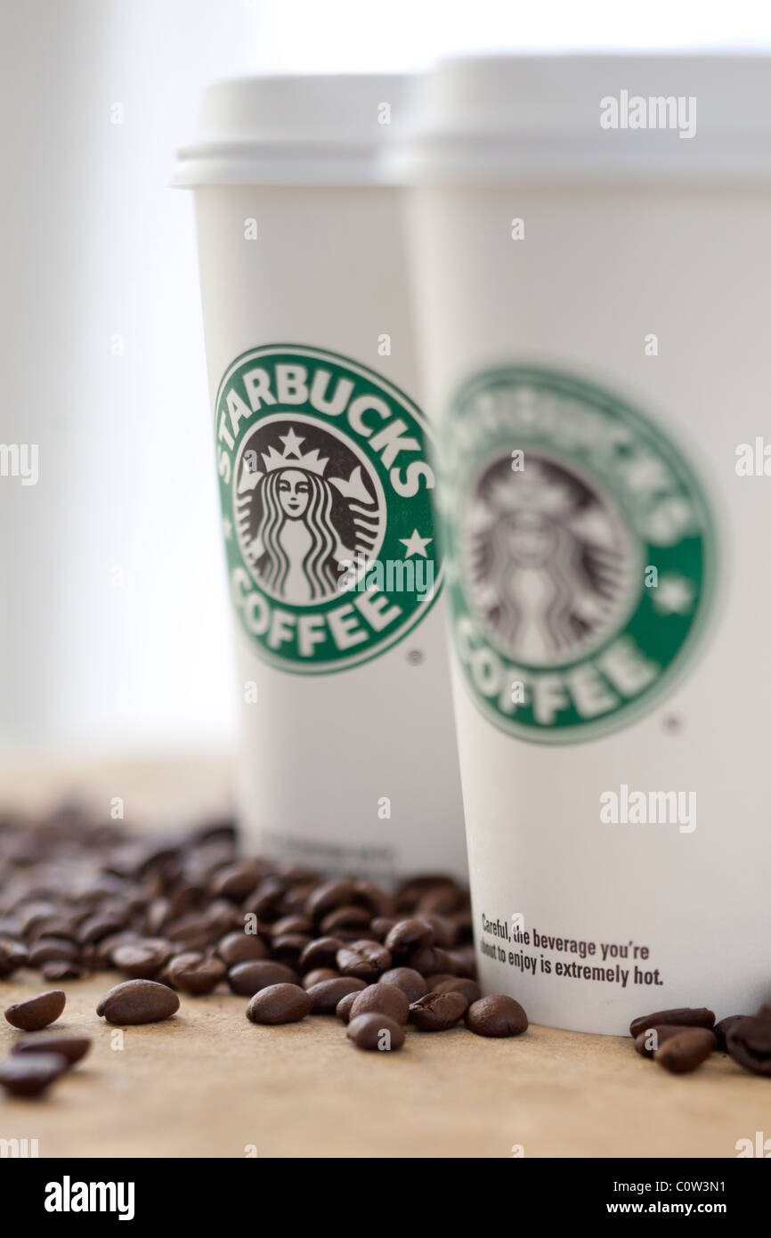 Two Starbucks to go coffee cups with beans Stock Photo