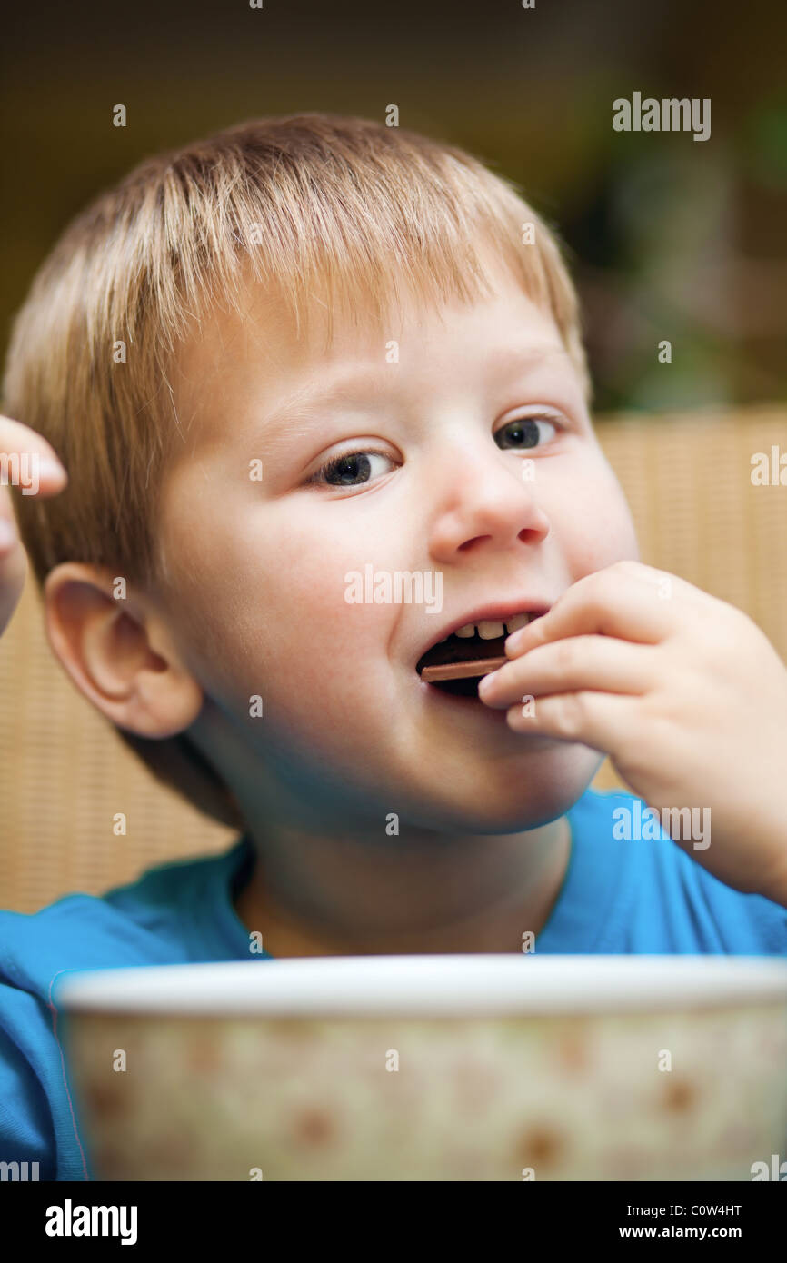 Cute little blond boy eating a snack Stock Photo