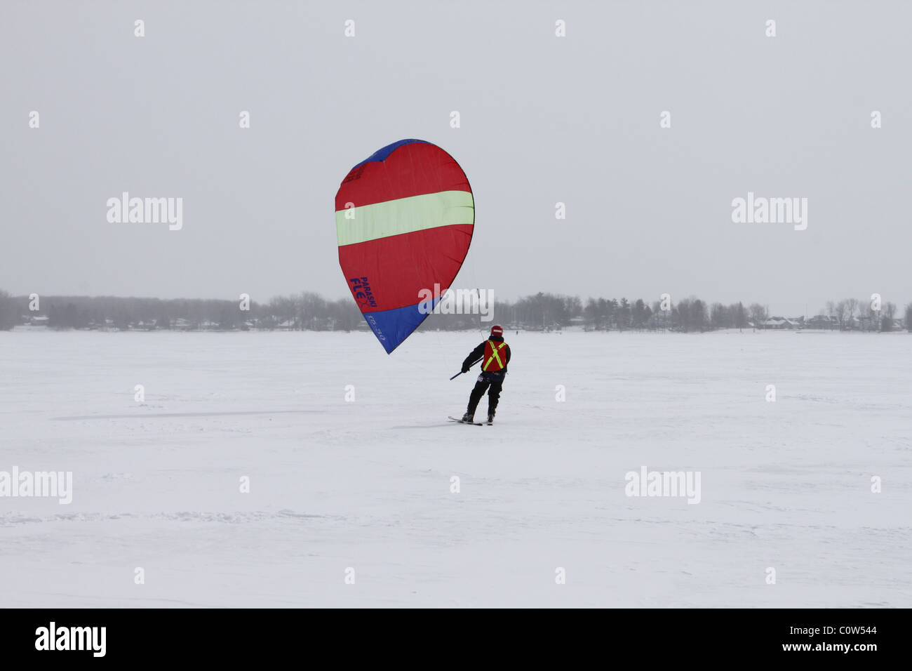 One man skiing on ice with red kite Stock Photo