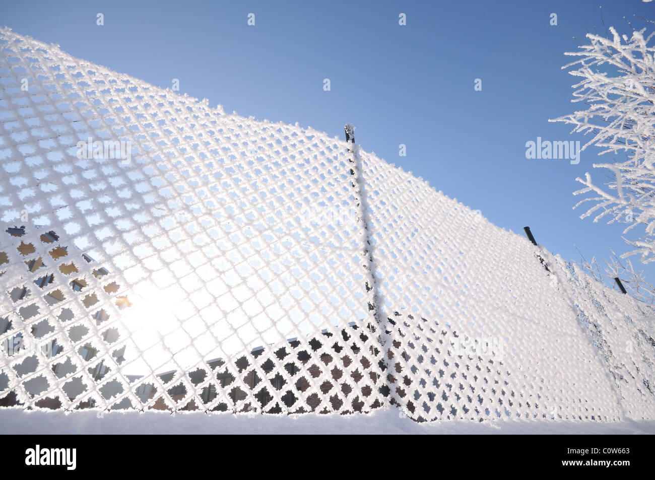 Fence covered by frost, sunny day Stock Photo