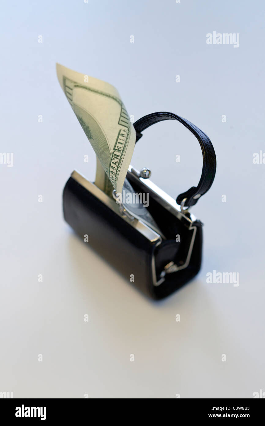 Open little black purse with one hundred dollar bill coming out Stock Photo
