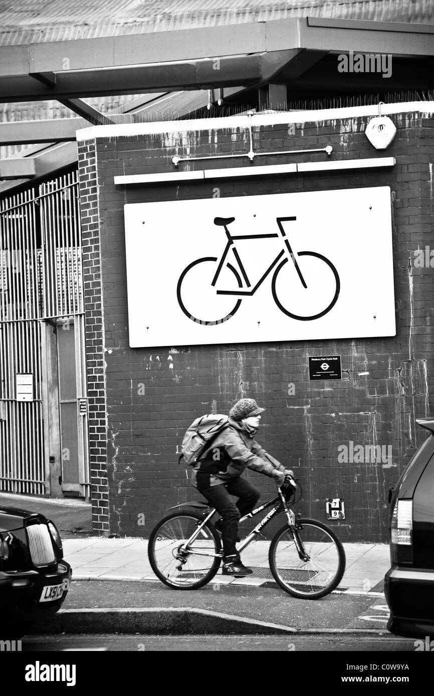 Cyclist on a bicycle passes a sign of a bicycle Stock Photo