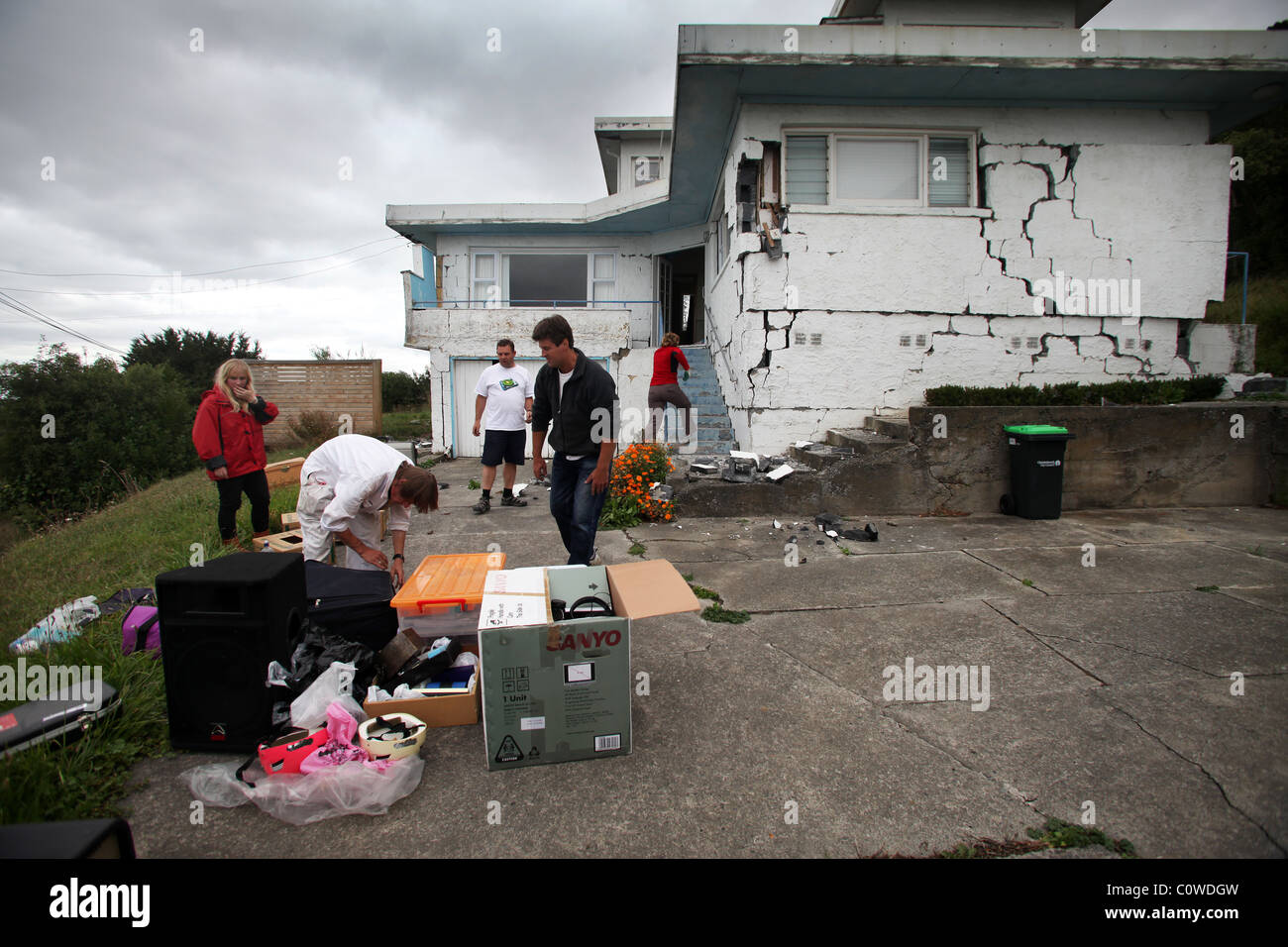 Residents hurry to remove property from a badly damaged house in Sumner