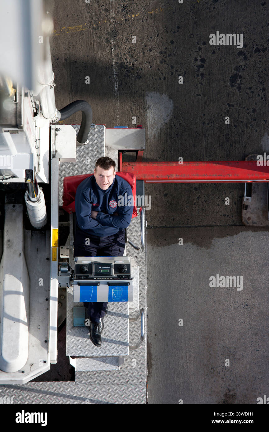 Fireman at controls of hydraulic lift, Ireland Stock Photo