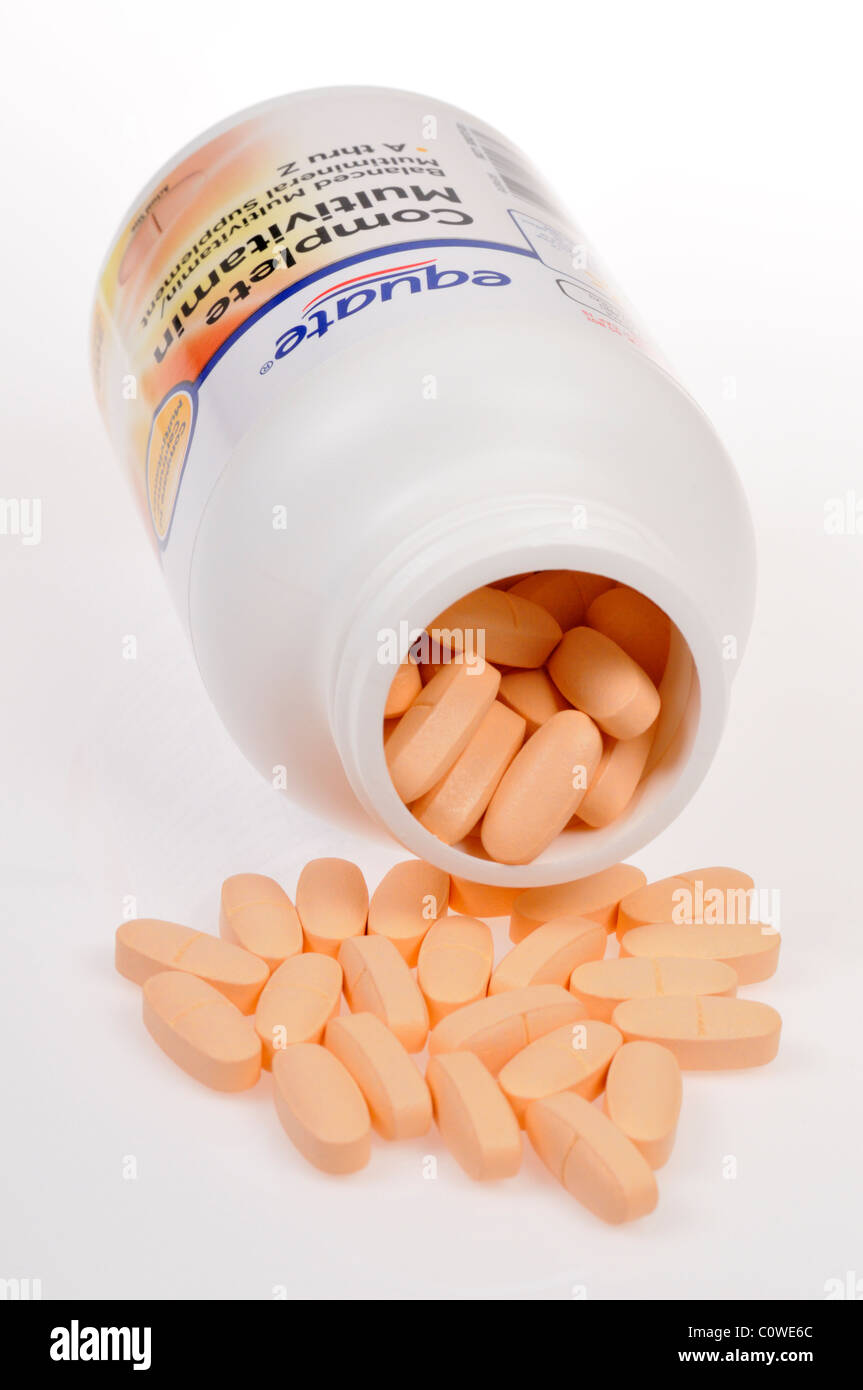 Open bottle of Equate Multivitamins  on its side with tabs scattered on white background. Stock Photo