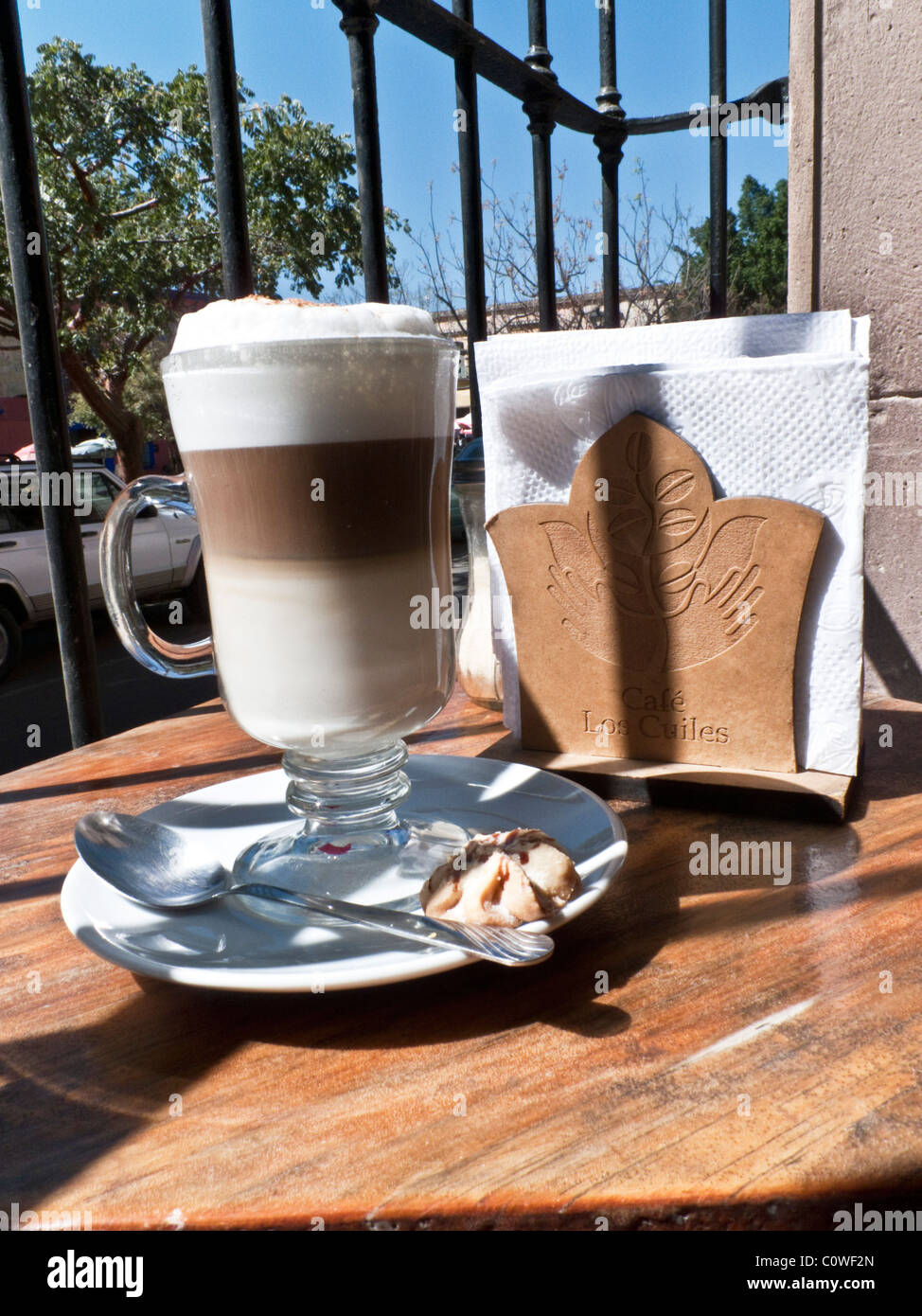 perfect glass of cappuccino with cookie sitting in sun by an open window with view of pure blue sky in Oaxacan cafe Mexico Stock Photo