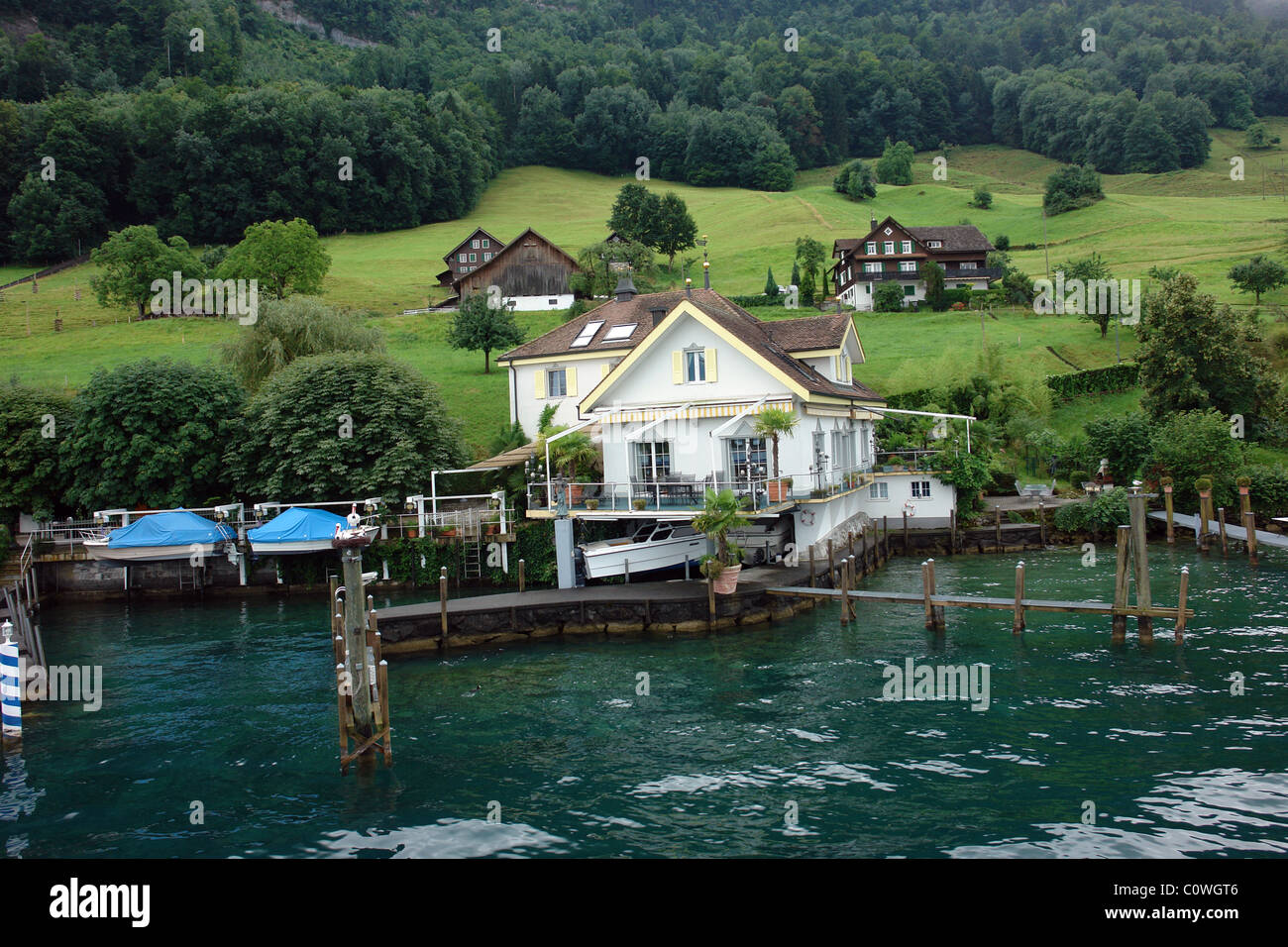 A house, pier and boats, on the shore of Lake Lucerne in Switzerland