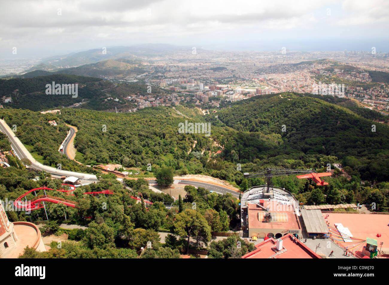 Wide-angle view of Barcelona’s suburbs and the Tibidabo Theme Park, Bottom right, the Vintage Avio plane ride is in operation Stock Photo