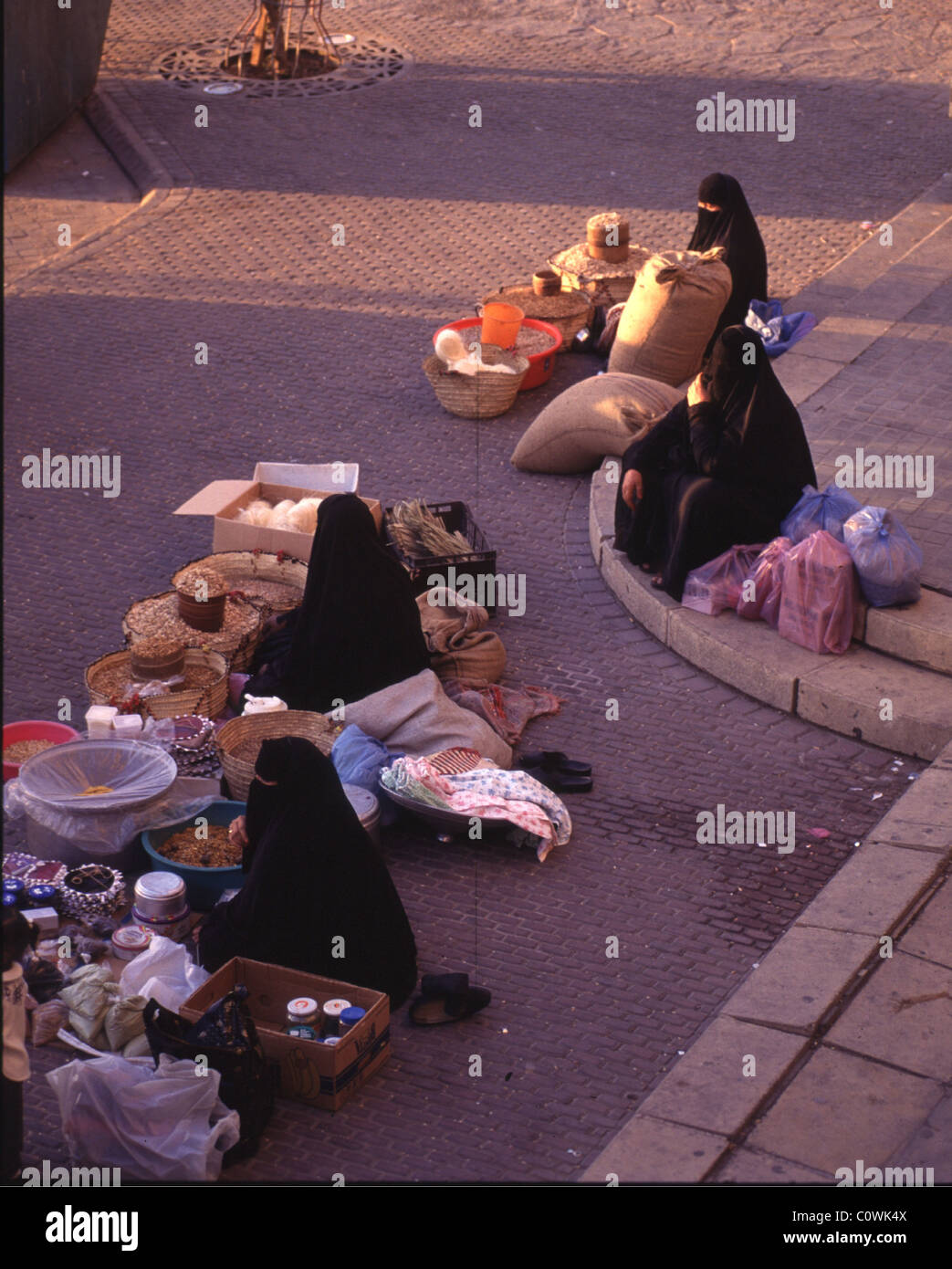 riyadh, saudi arabia -- women sell their wares on the sidewalk at a local market. Stock Photo