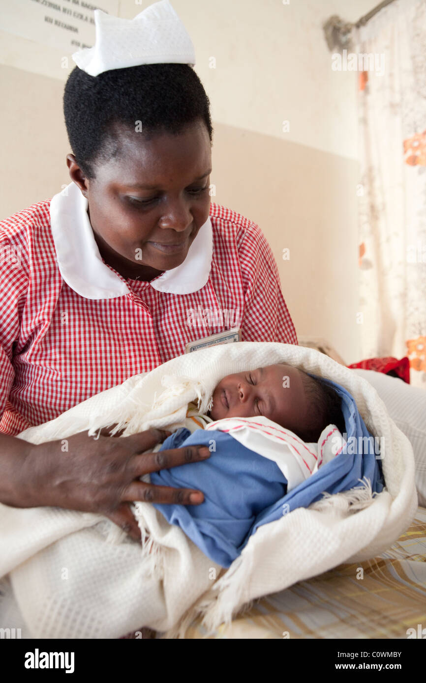 A nurse holds a newborn baby in a clinic in Jinja District, Uganda