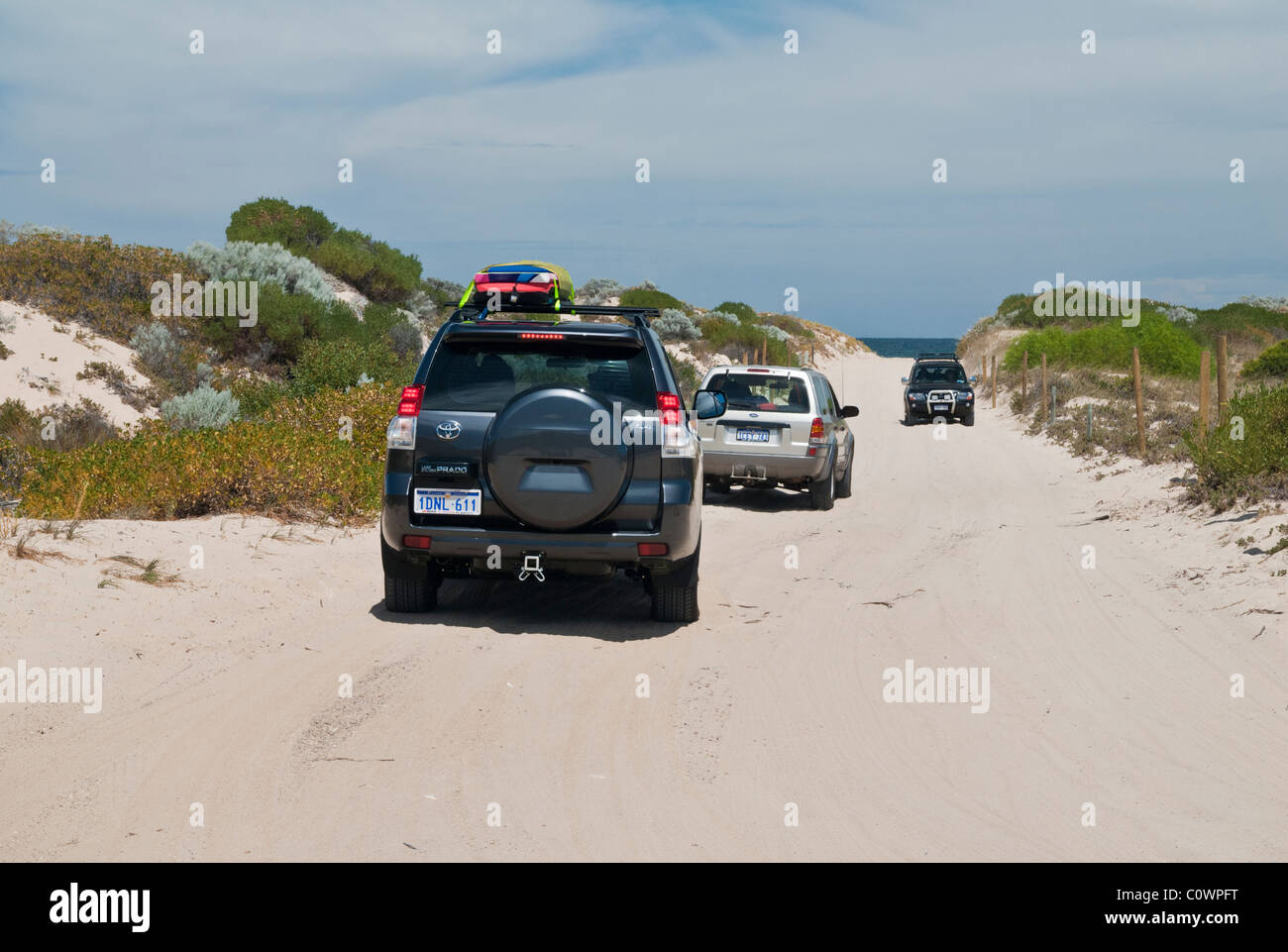 Four-wheel drive vehicles driving through soft sand at Preston Beach, Western Australia Stock Photo