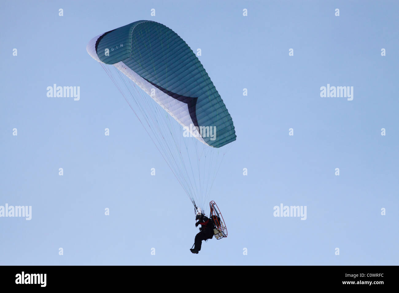 Flying Man - motorized paraglider flying on a clear day Stock Photo
