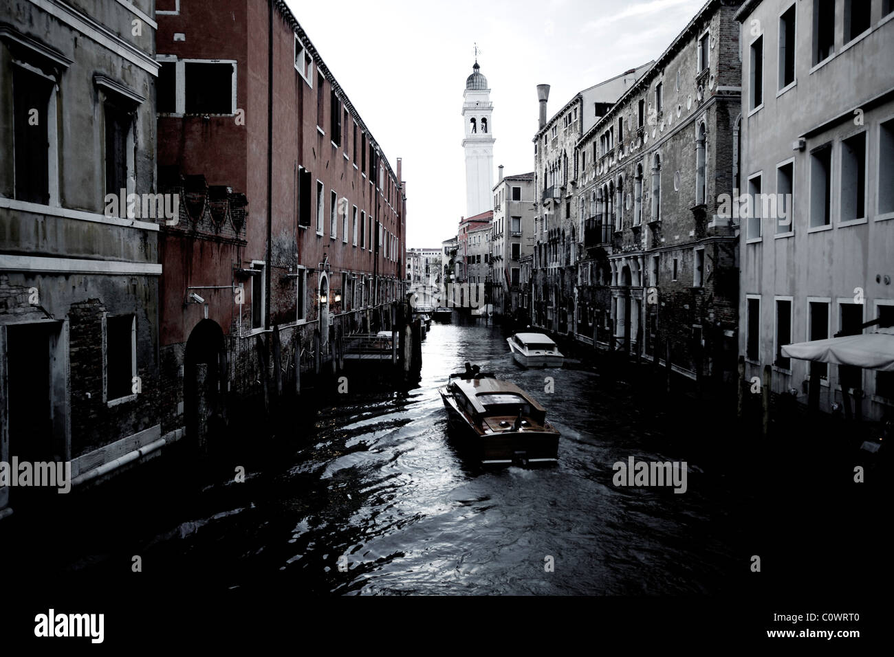 A venetian waterway in Venice Italy with a motorboat taxi commuting on it. Stock Photo