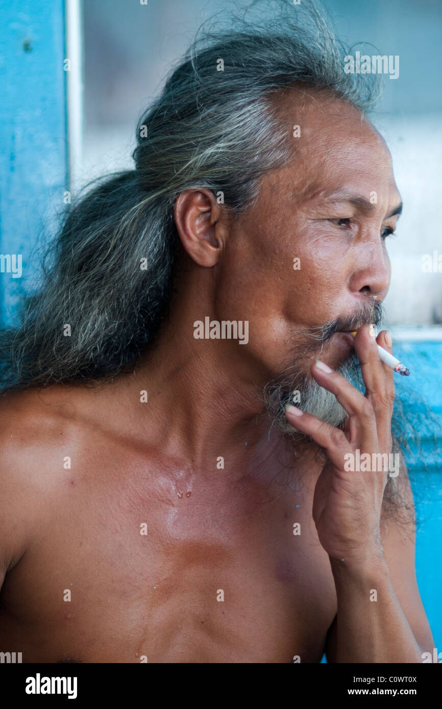 Portrait of a Vietnamese man smoking on a boat during a day trip to Nha ...