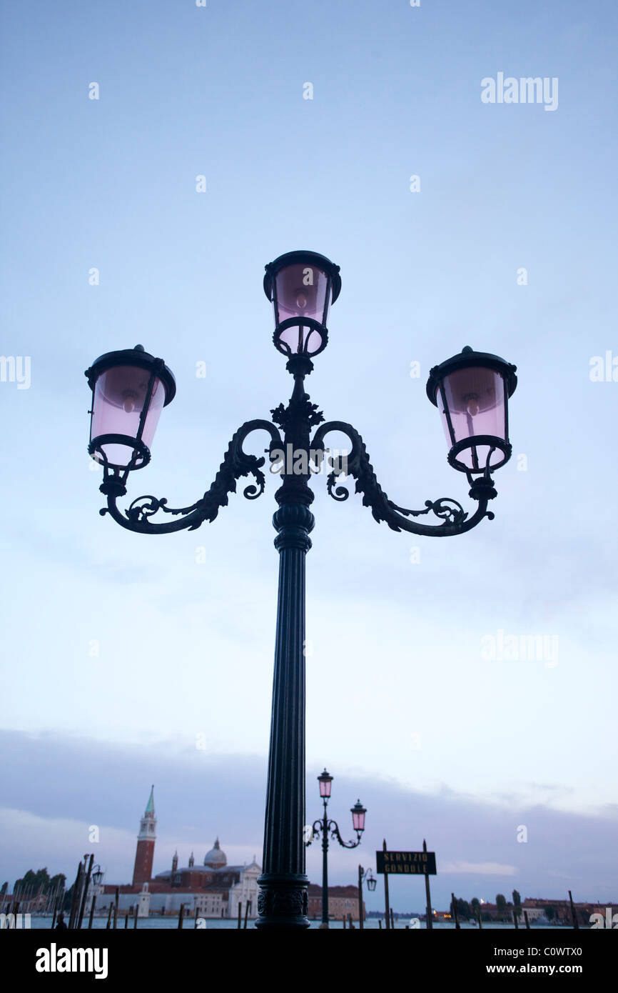 A street light / lamp along the river bank in Venice Italy with a church in the background Stock Photo