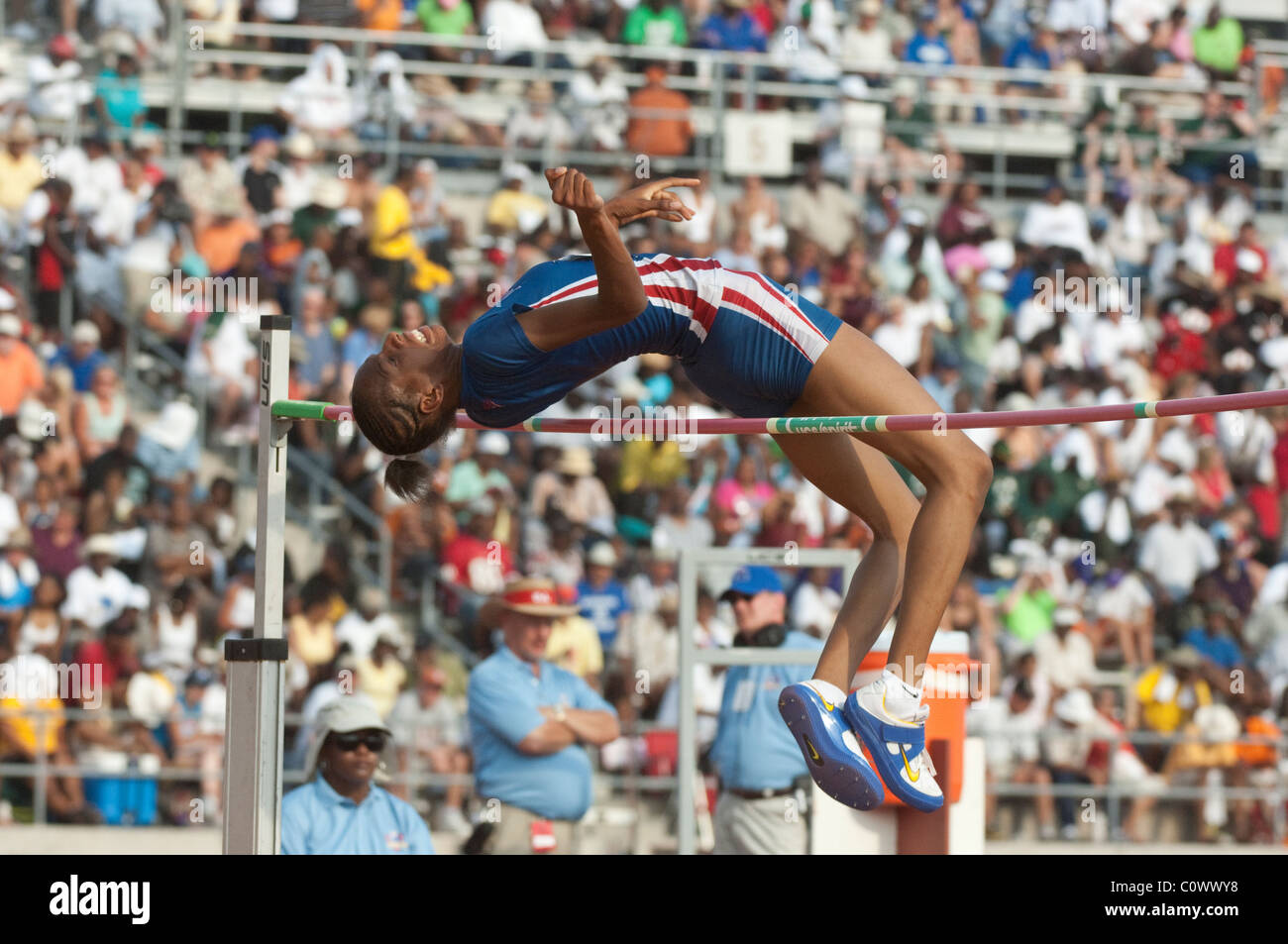 African-American girl clears the high jump bar at the Texas high school state track and field meet in Austin Stock Photo