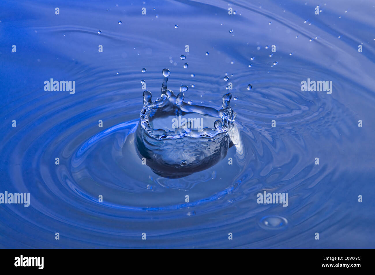Droplet splashing into a pool of water Stock Photo - Alamy