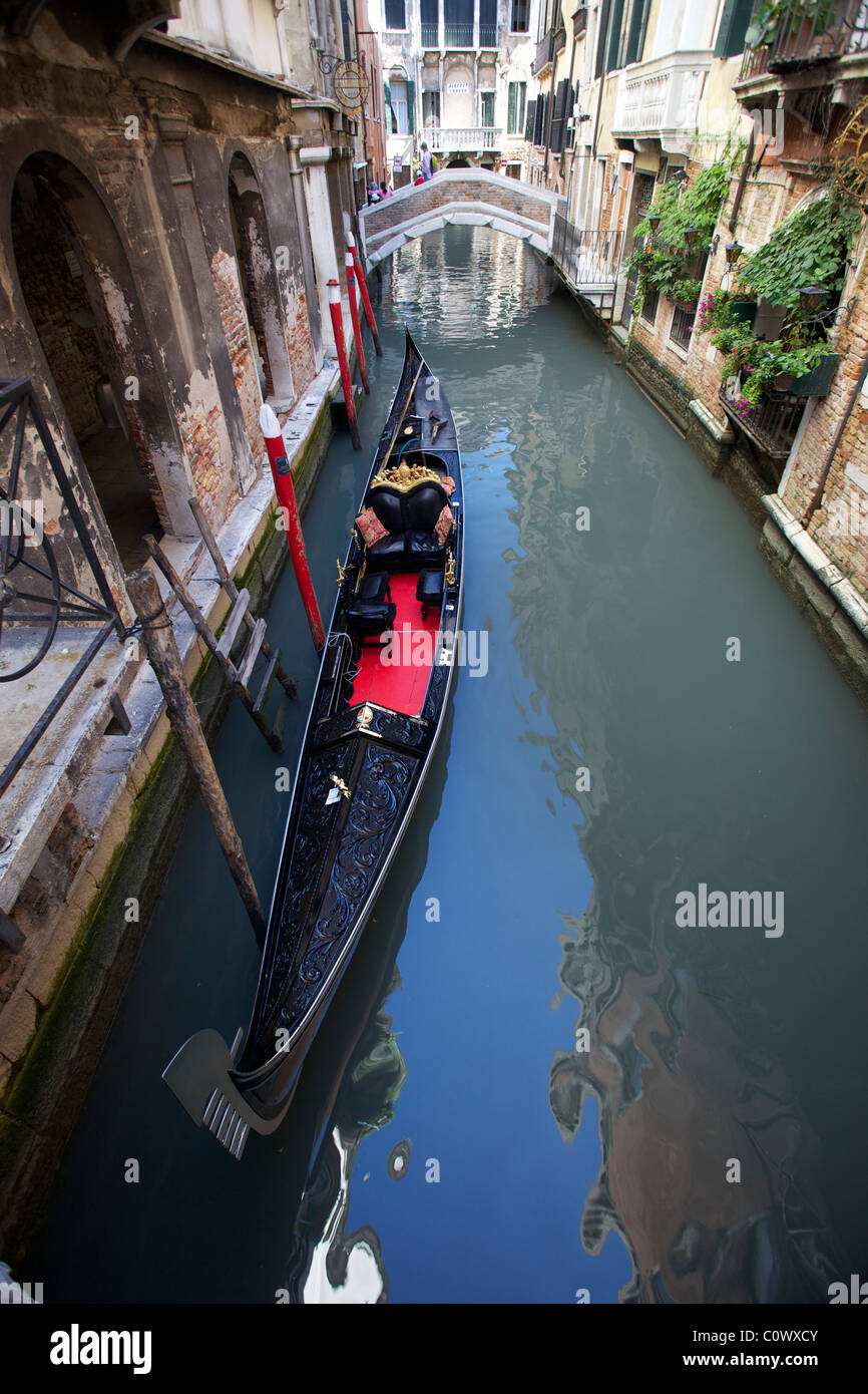 A traditional venetian gondola on a canal in Venice, Italy Stock Photo