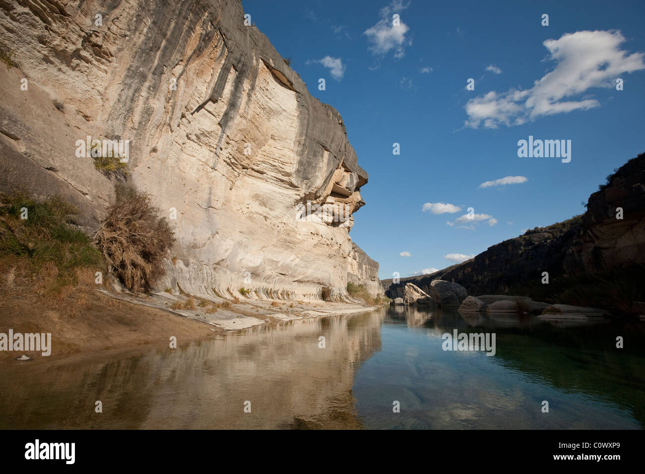 Reflection of blue sky and limestone cliff on the Pecos River in the Amistad National Recreation Area in west Texas. Stock Photo