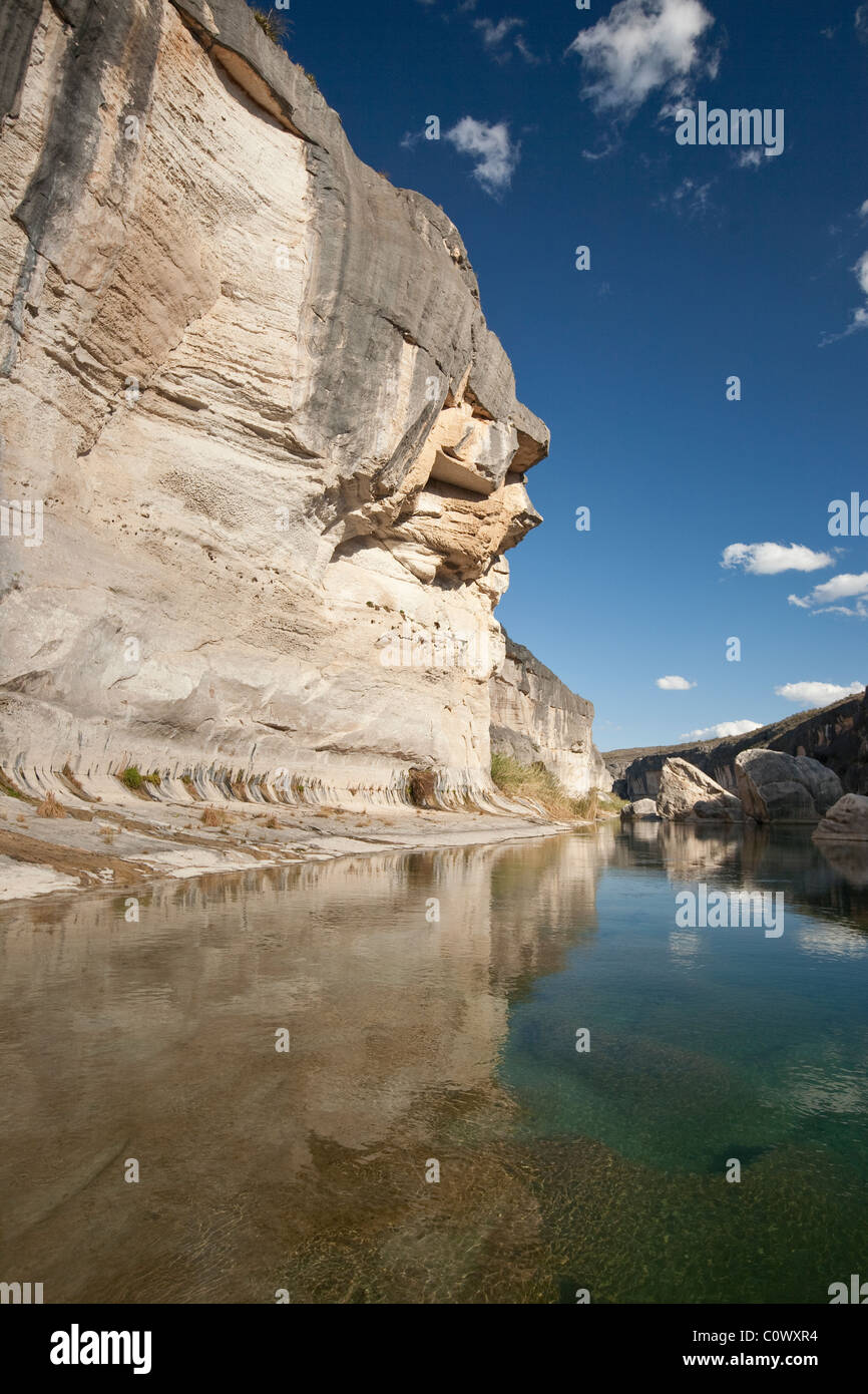 Reflection of blue sky and limestone cliff on the Pecos River in the Amistad National Recreation Area in west Texas. Stock Photo
