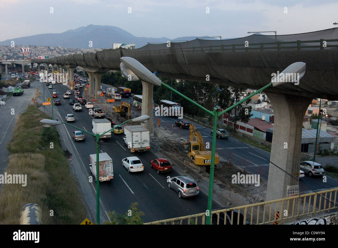 Traffic in Mexico beneath a viaduct under construction Stock Photo