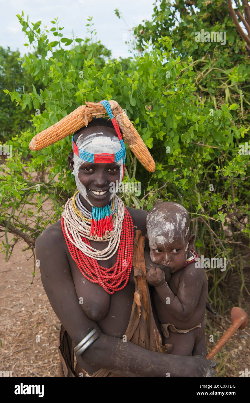 Karo woman with colorful necklaces holding a suckling baby, Omo river valley, Omo river valley, Southern Ethiopia Stock Photo