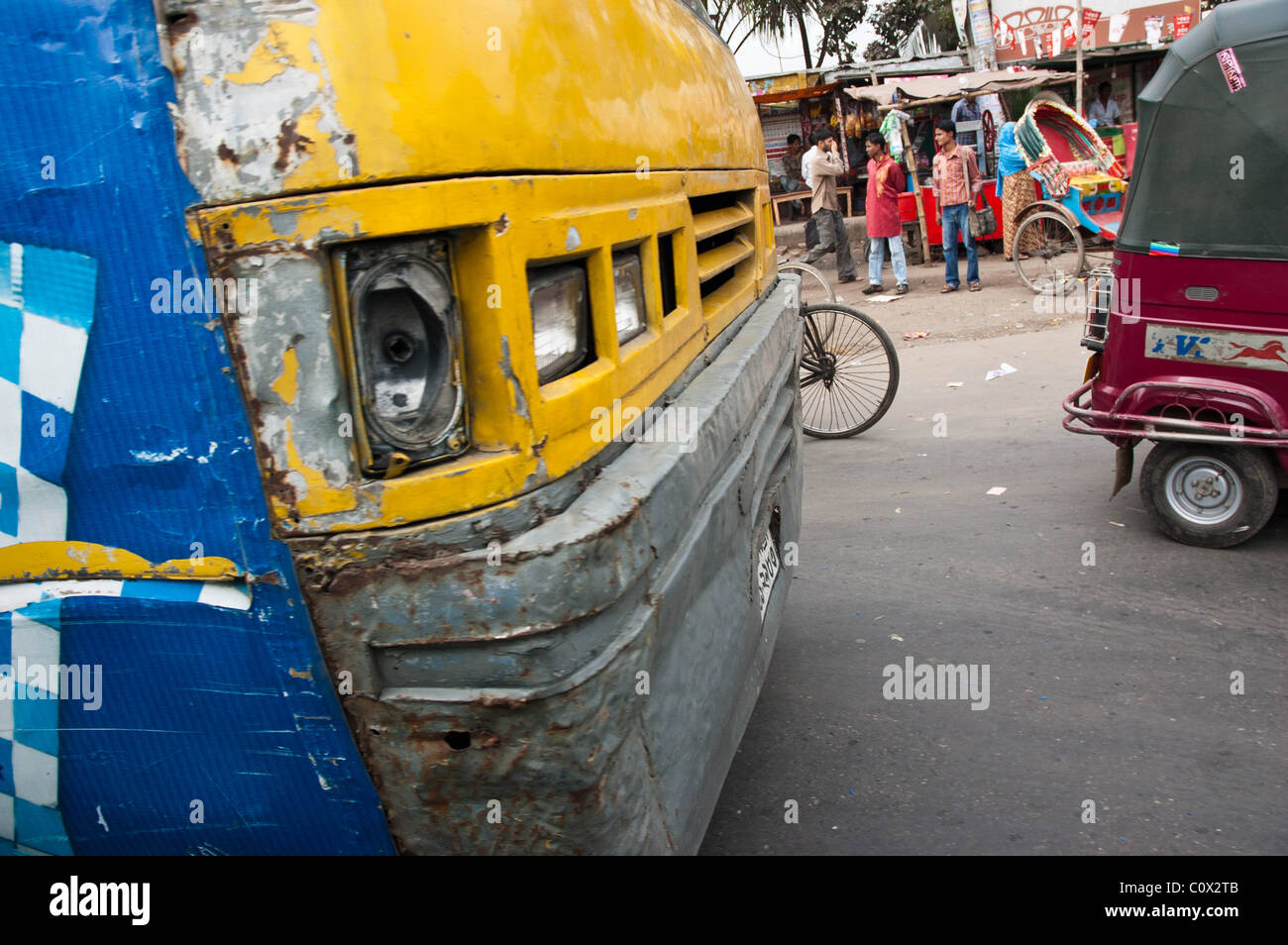 The front of a battered Bangladeshi bus, in the middle of a Dhaka street scene Stock Photo