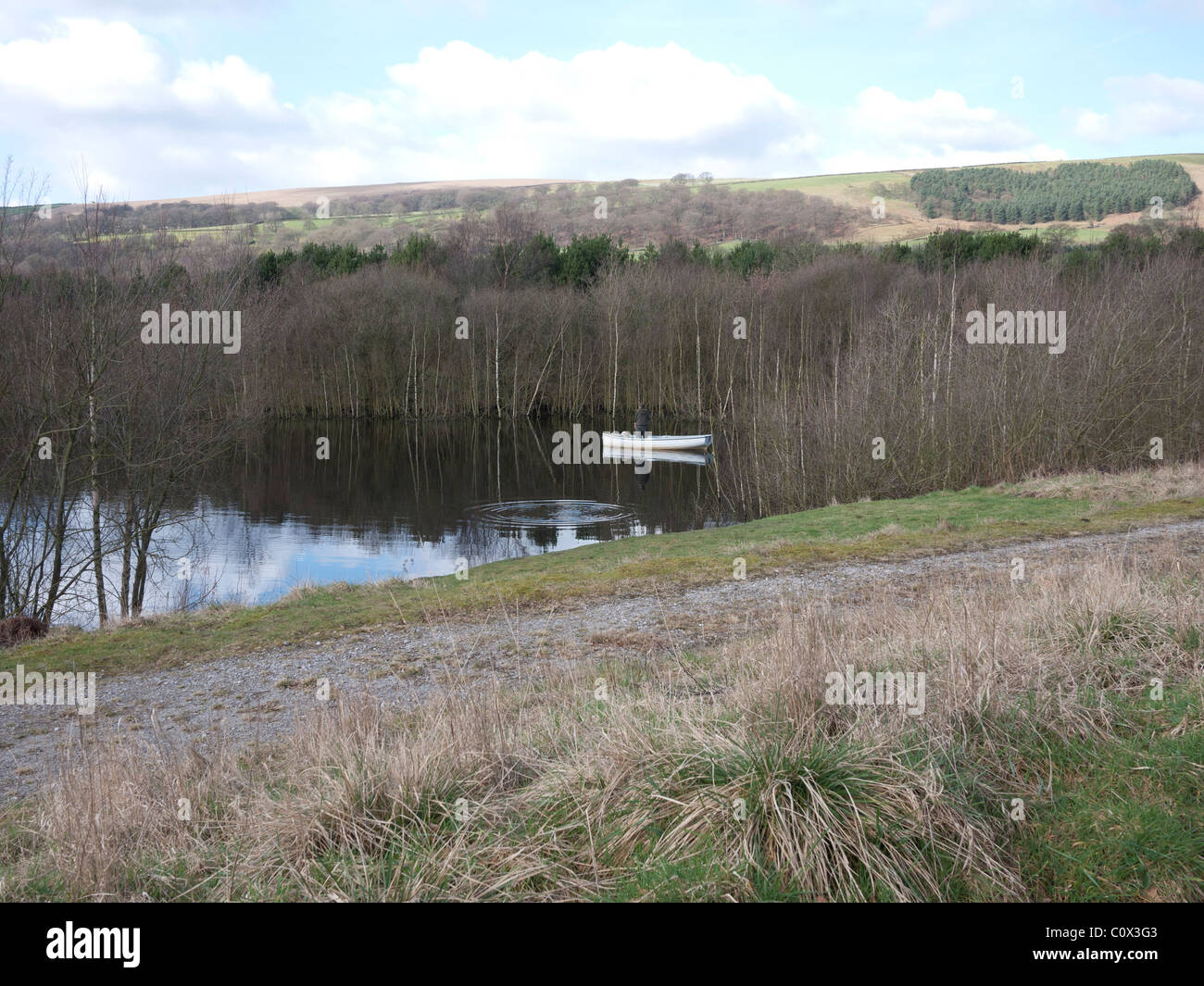 Trout fisherman fly fishing from a boat, Derbyshire, England, UK Stock