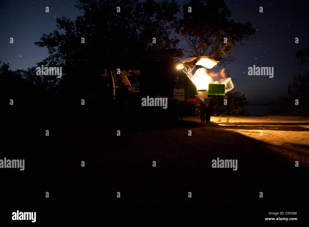 Campers prepare nighttime meal behind campervan. Magnetic Island, Townsville, Queensland, Australia Stock Photo