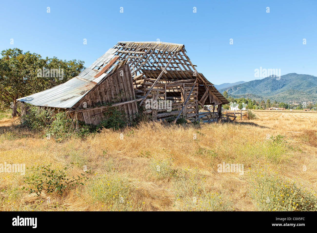 Old dilapidated barn falling apart in field of farm/ranch in Applegate Valley, Oregon. Stock Photo