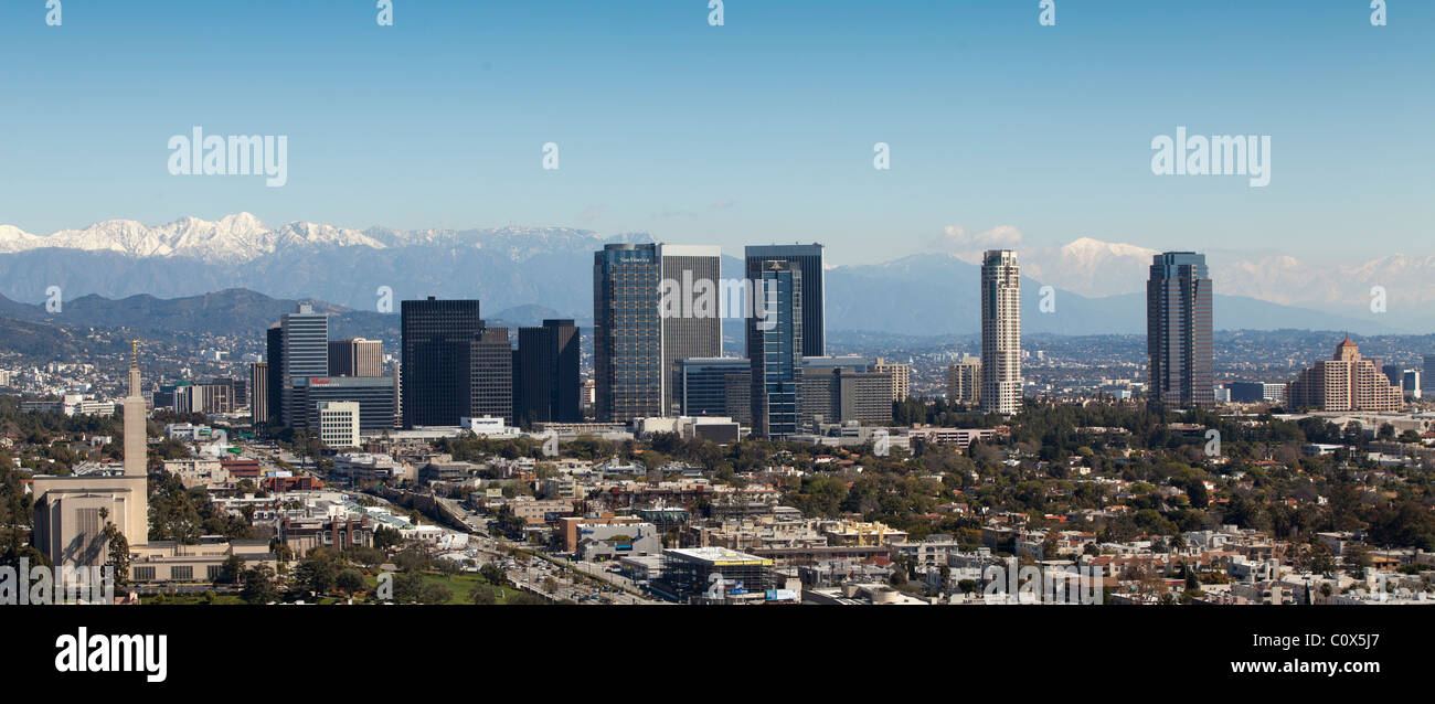 Skyline of Century City area of Los Angeles after a winter storm featuring snow on mountains in background. Stock Photo