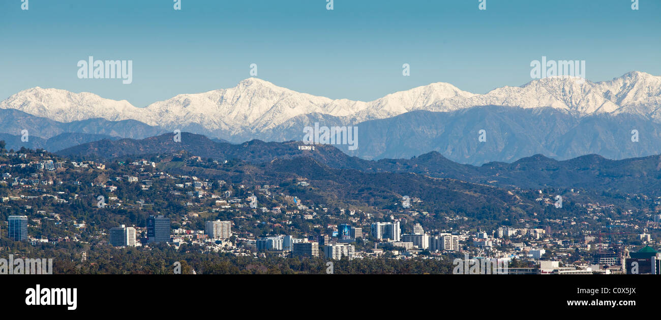 Skyline of Los Angeles after a winter storm featuring snow on mountains in background.  HOLLYWOOD sign is visible. Stock Photo