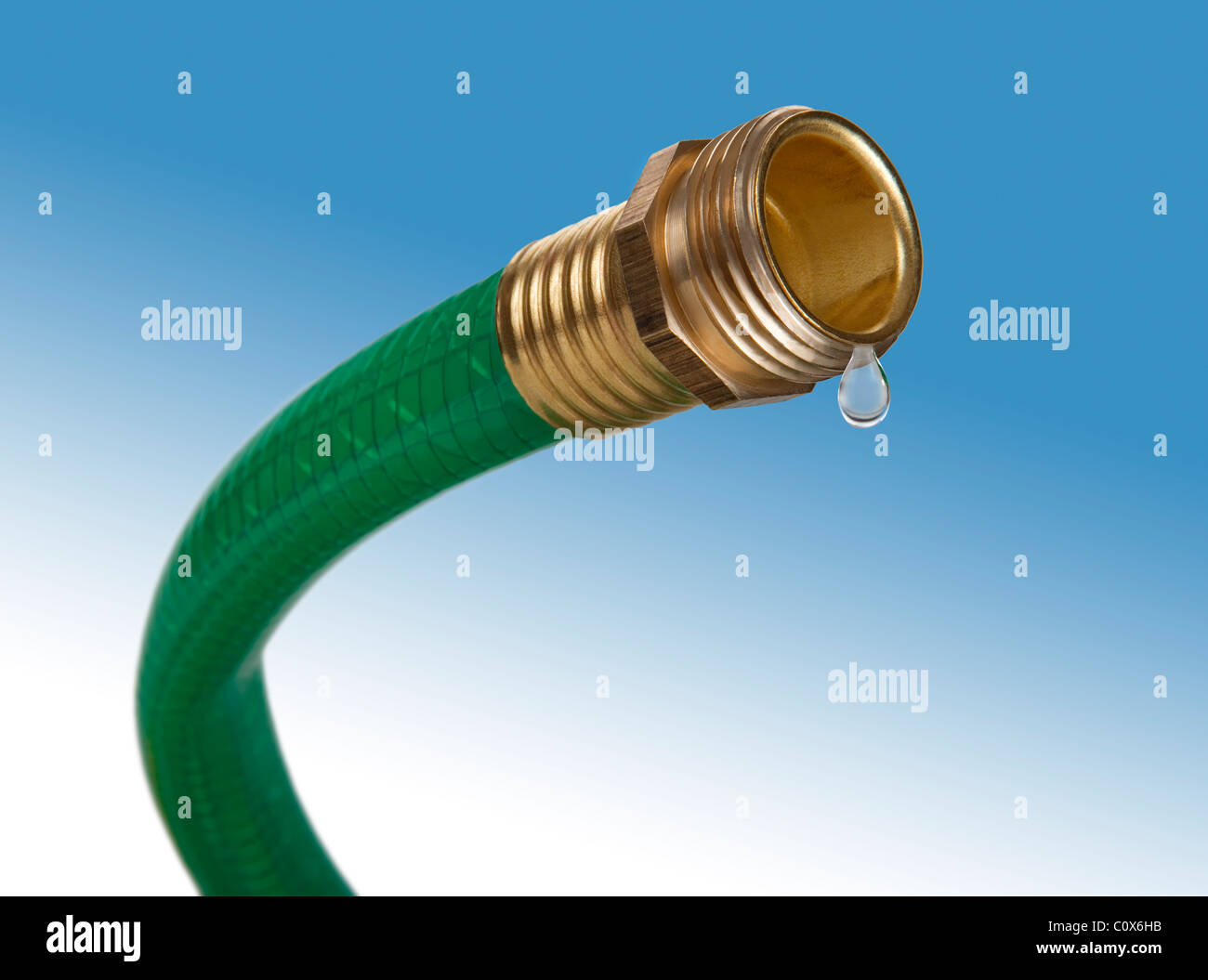 A green garden hose with only one drop of water coming out Stock Photo
