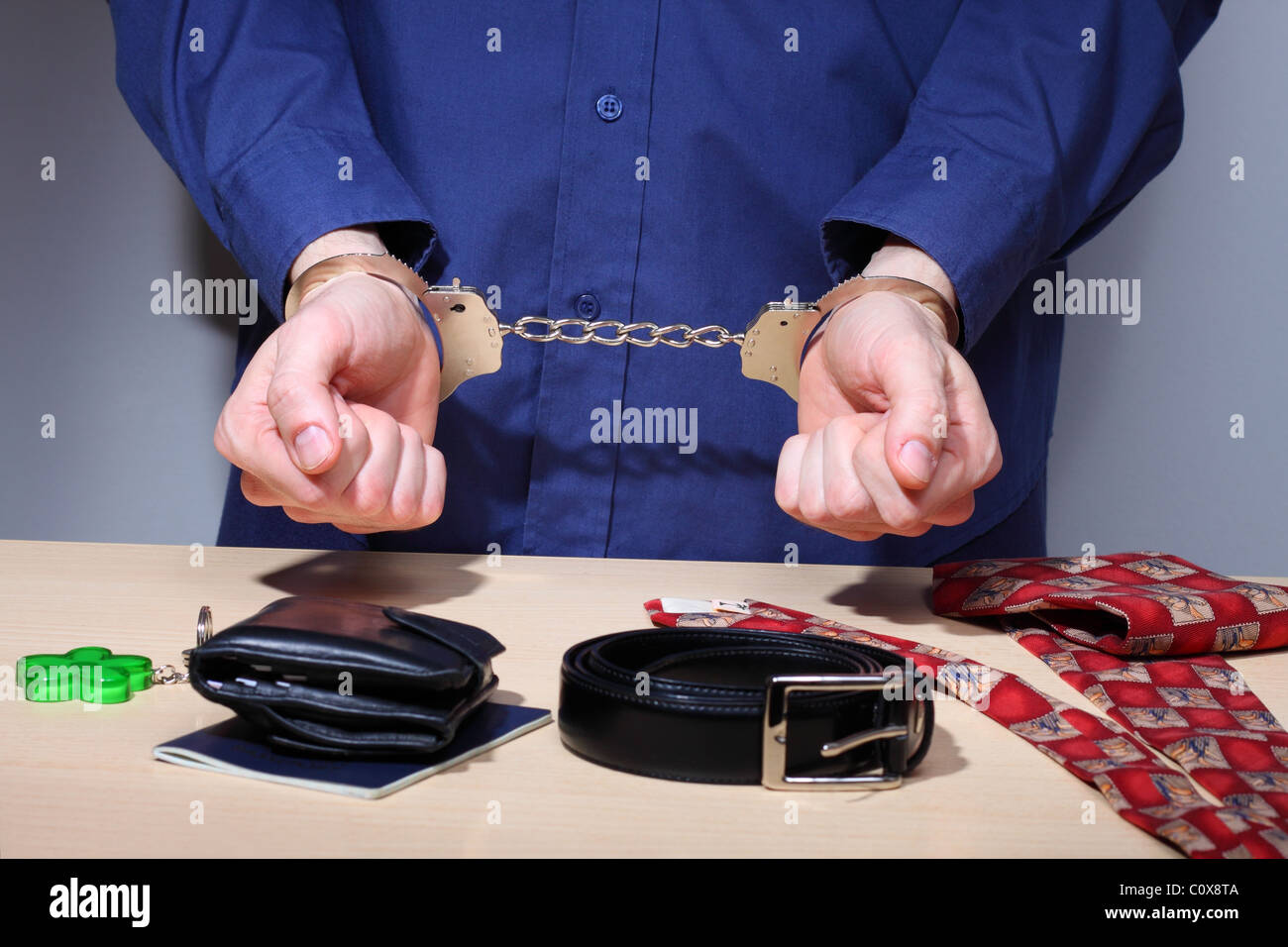 Businessman with handcuffs, stripped of personal items during arrest Stock Photo