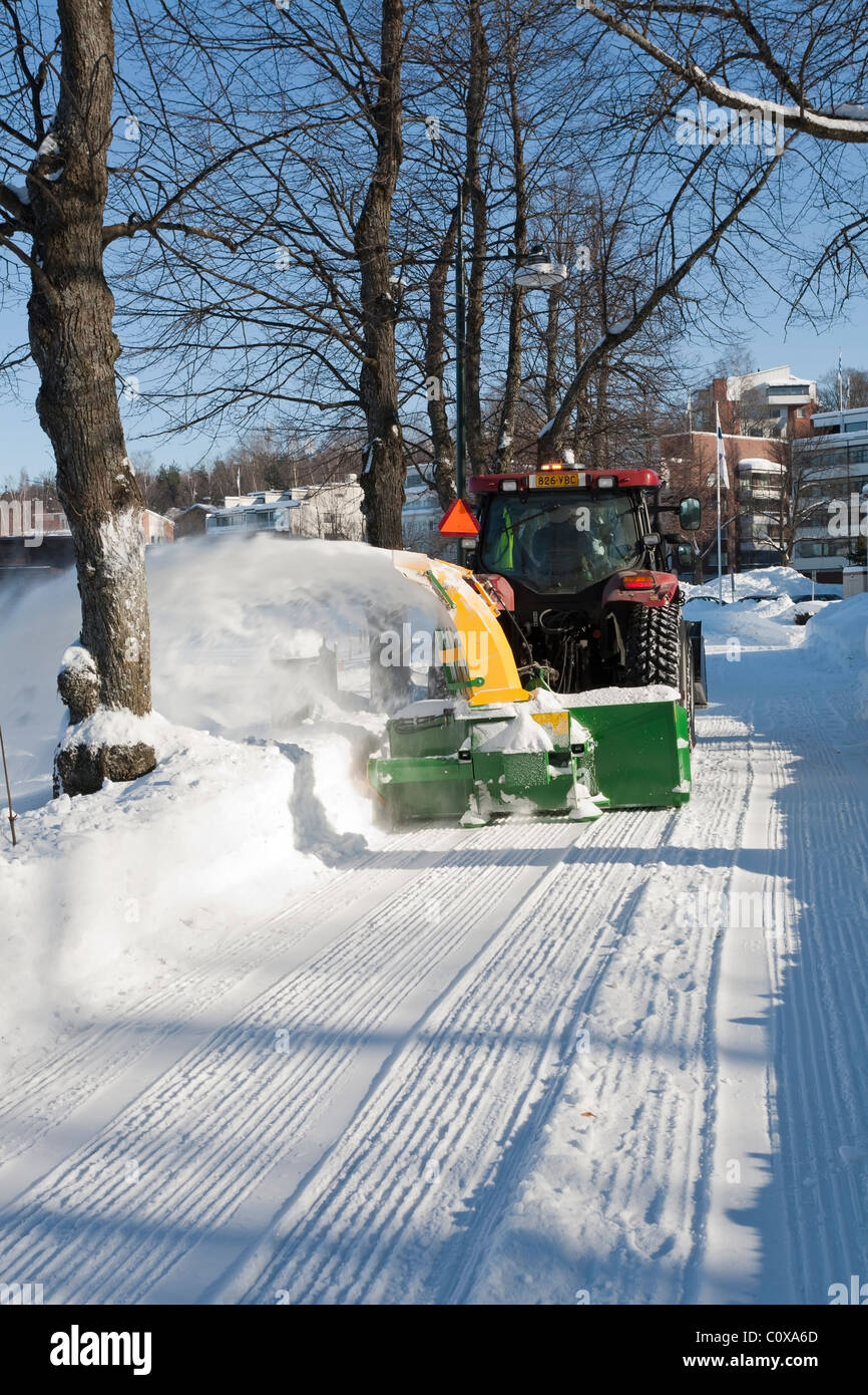 Tractor clearing snow off the walkway Finland Stock Photo Alamy