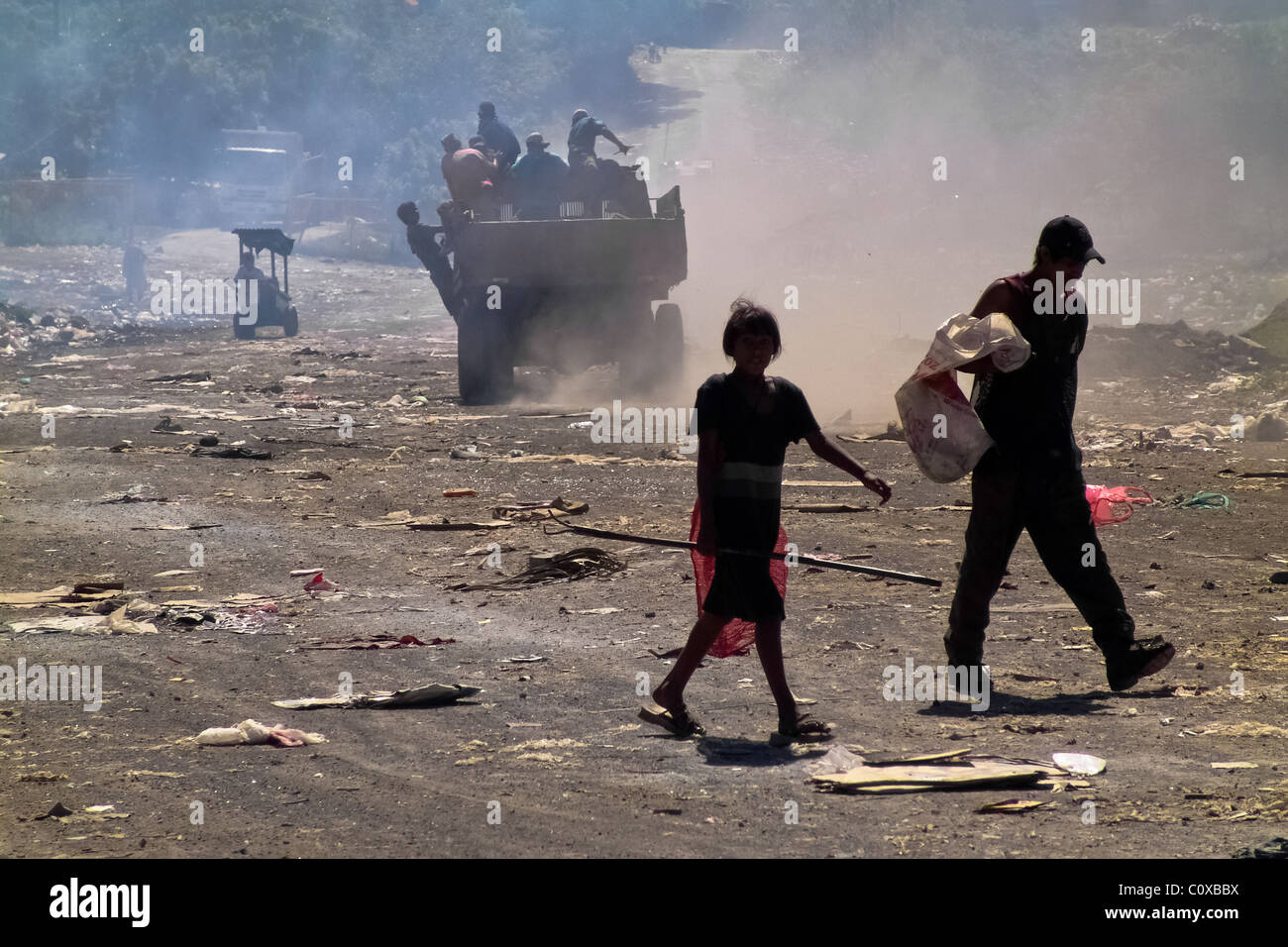Nicaraguan garbage recollectors, walking in a dust cloud, work in the