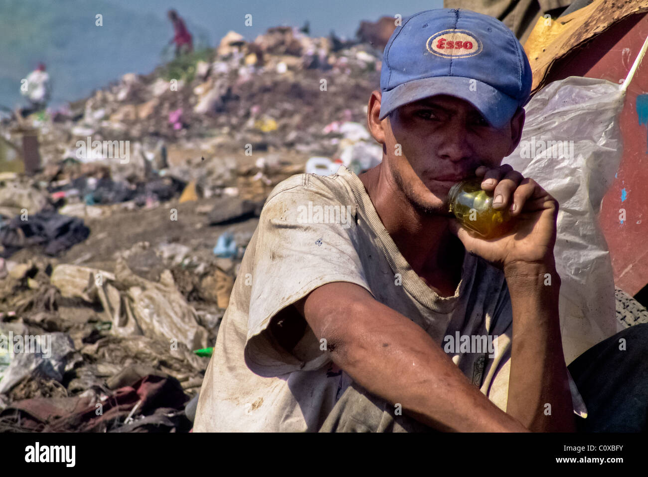 A Nicaraguan boy, a garbage recollector, sniffs glue in the garbage dump La Chureca, Managua, Nicaragua. Stock Photo