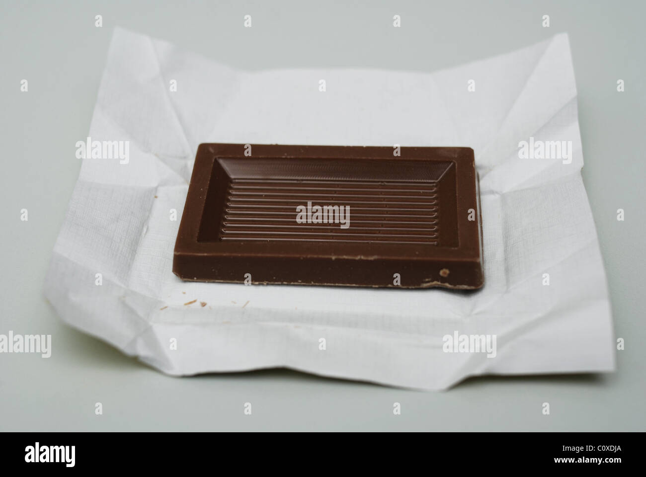 Single portion of chocolate on wrapper. Stock Photo