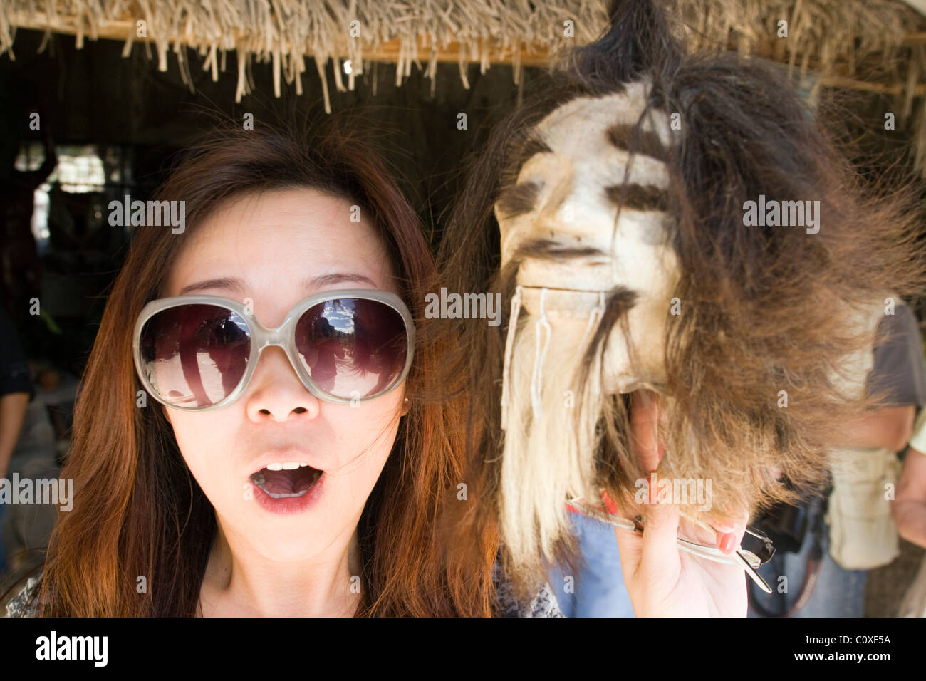 Young female tourist with Shrunken Head - Museo Solar Inti Nan - near Quito, Ecuador Stock Photo