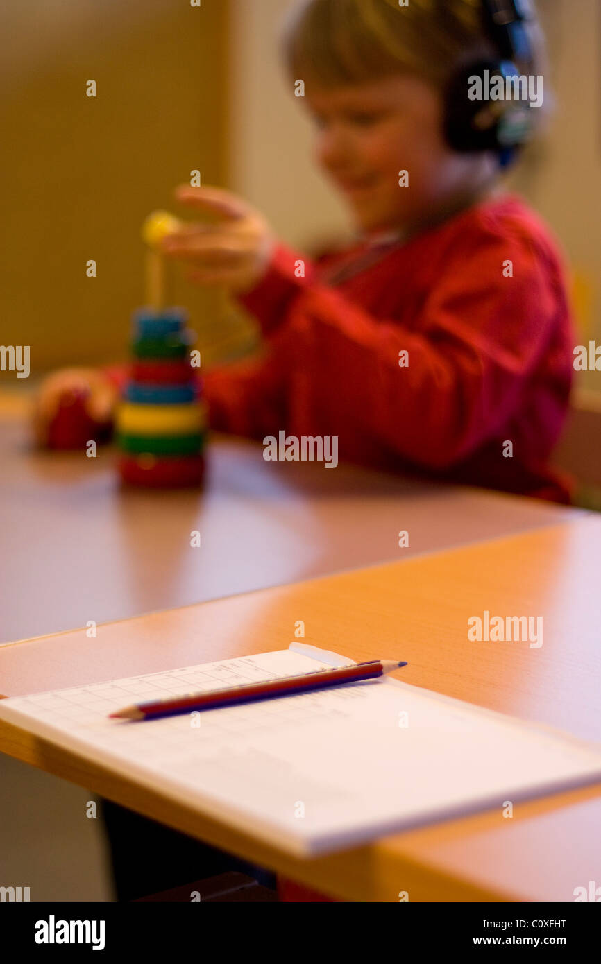 Child doing a hearing test, audiometry form in the foreground. Stock Photo