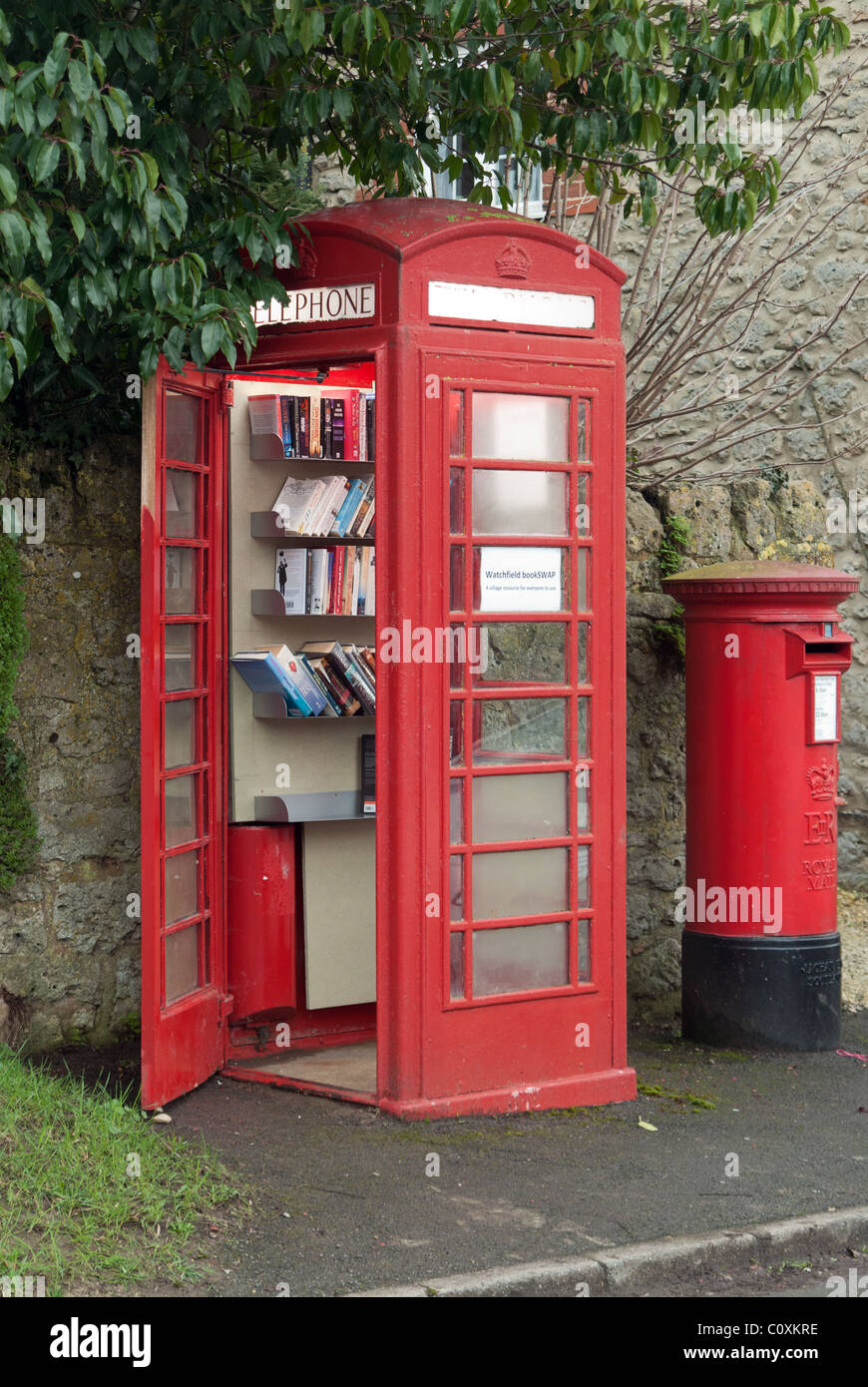 A UK village's redundant BT red telephone box now adopted by the parish council, and converted into a 'Bookswap' mini library. Stock Photo