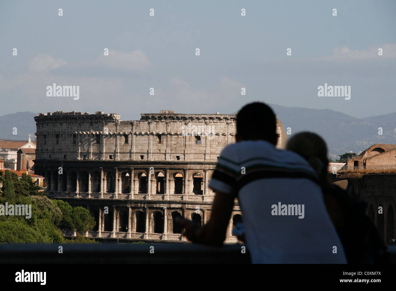 young couple looking towards the colosseum coliseum in rome italy Stock Photo