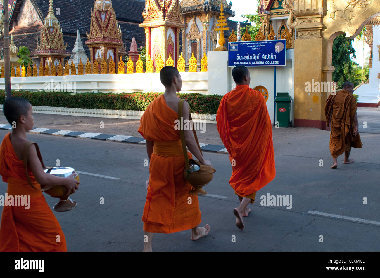 Monks returning to temple after alms collection, Wat Louang, Pakxe, Laos Stock Photo