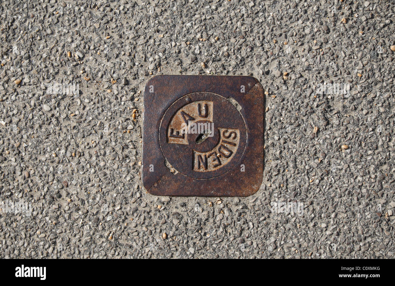 A water main access point on the street in Esquelbecq, France. Stock Photo