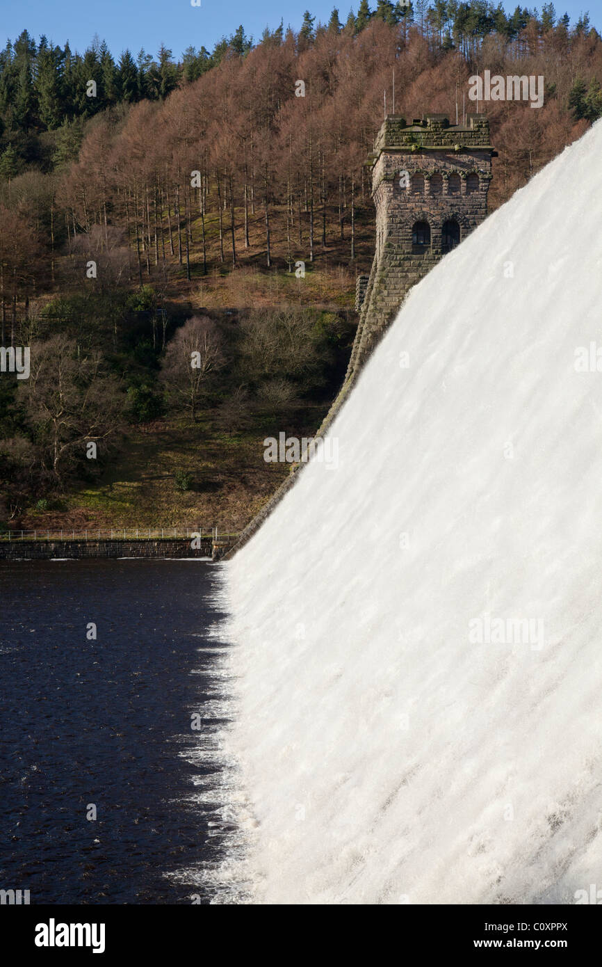 Water flowing, stone towers, trees on hillside Howden Dam at Upper Derwent Valley Reservoir in the Peak District, Derbyshire Stock Photo