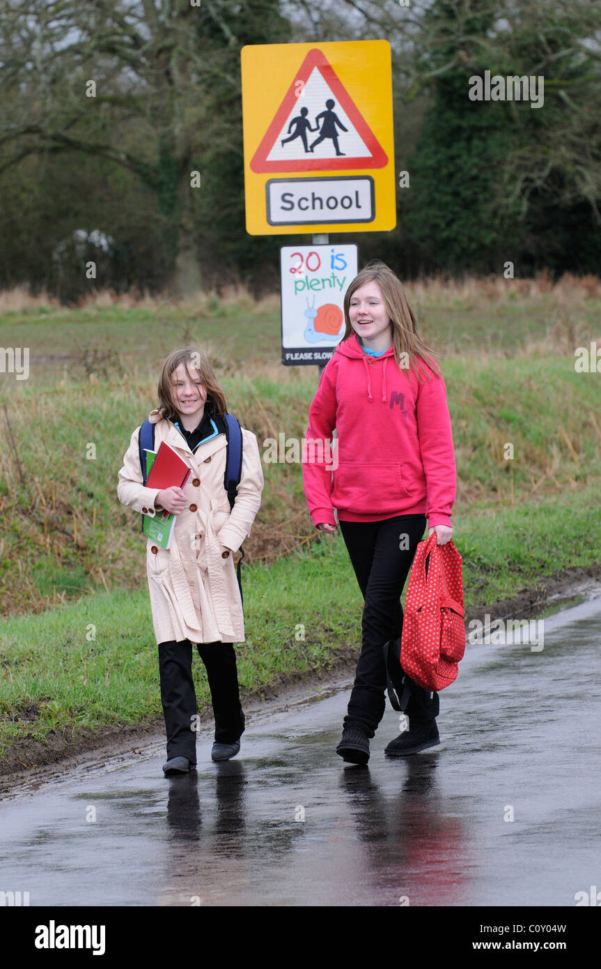 Schoolchildren walking from school along a country lane with no pavement Hampshire England UK Stock Photo